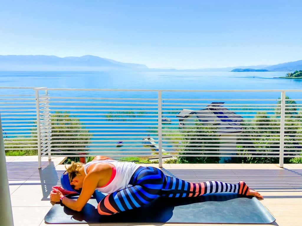 woman on a yoga mat outside demonstrating pigeon pose - the complete guide to lower body muscles