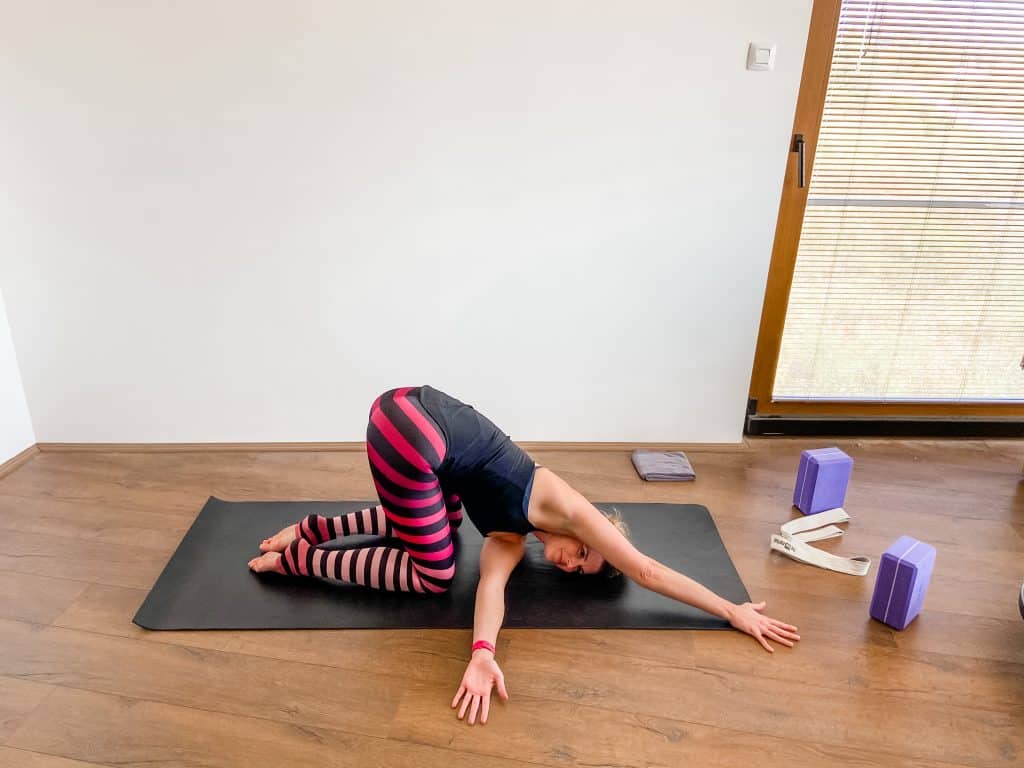 woman on a yoga mat demonstrating upper body stretches, thread the needle pose