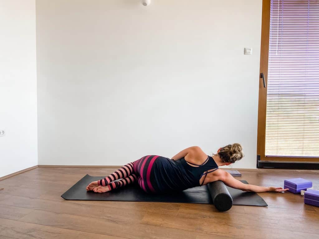 woman demonstrating foam rolling for lats