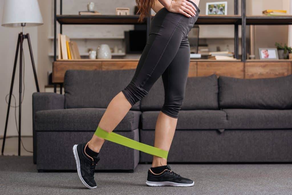 woman at home doing a workout with resistance bands; a decorative image in an article about gift ideas for fitness lovers
